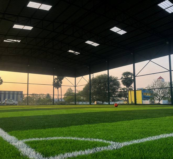 Concept image of an indoor covered football turf under a steel roof